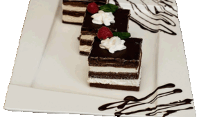 WZ – Biszkopt czekoladowy przełożony bitą śmietaną i cieniutką warstwą powideł, oblany czekoladą udekorowany różyczką z bitej śmietany.